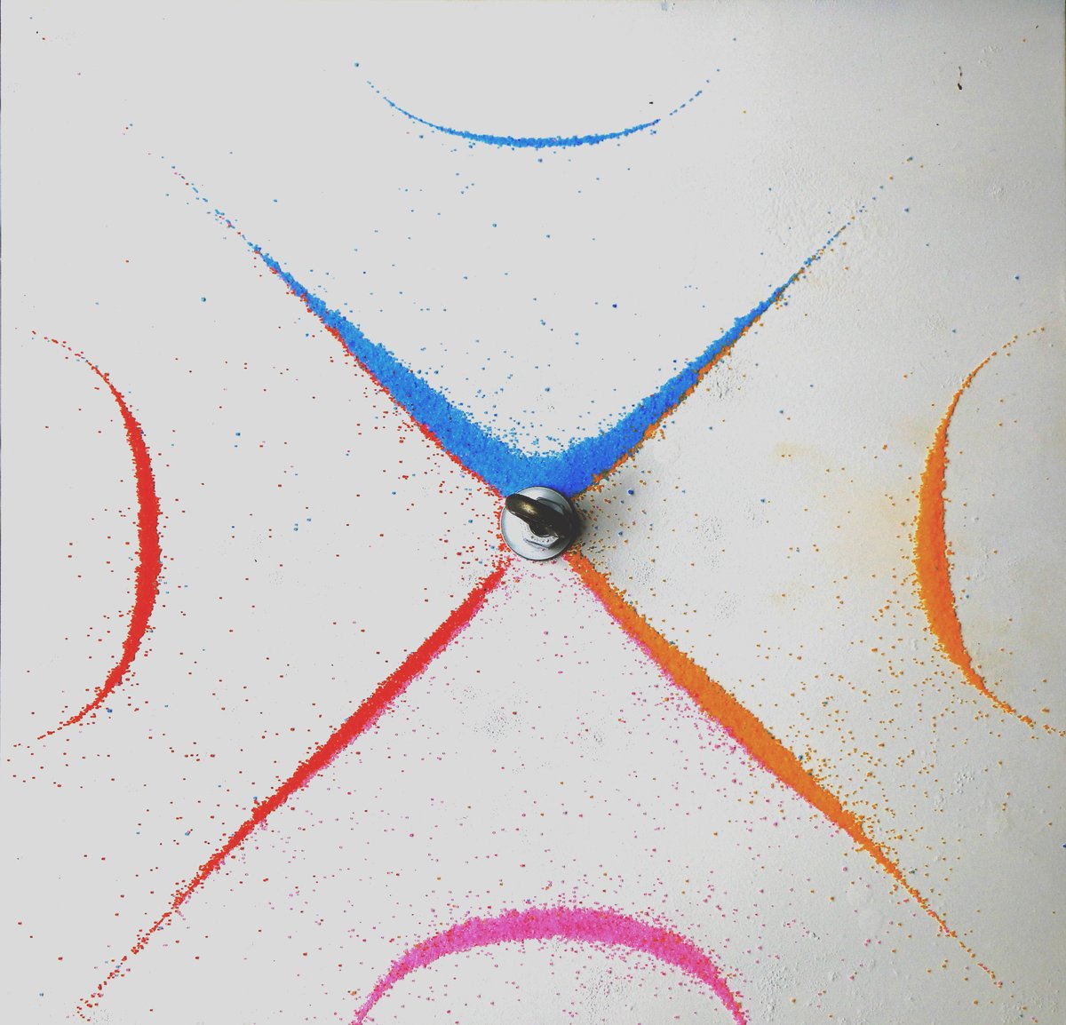 Chladni figure with coloured sand showing nodal lines and curved patterns on a vibrating plate