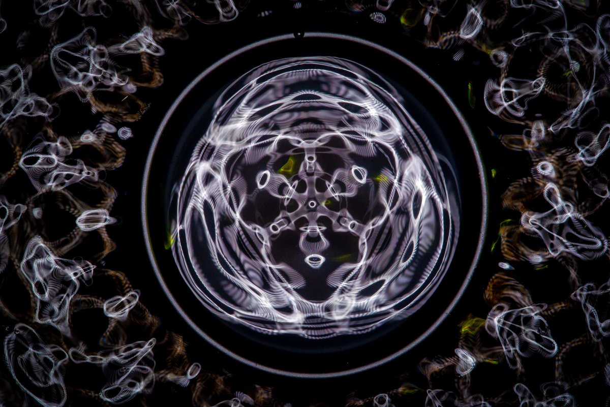 Cymatics pattern in water — sound vibration creating a six-fold symmetric mandala pattern